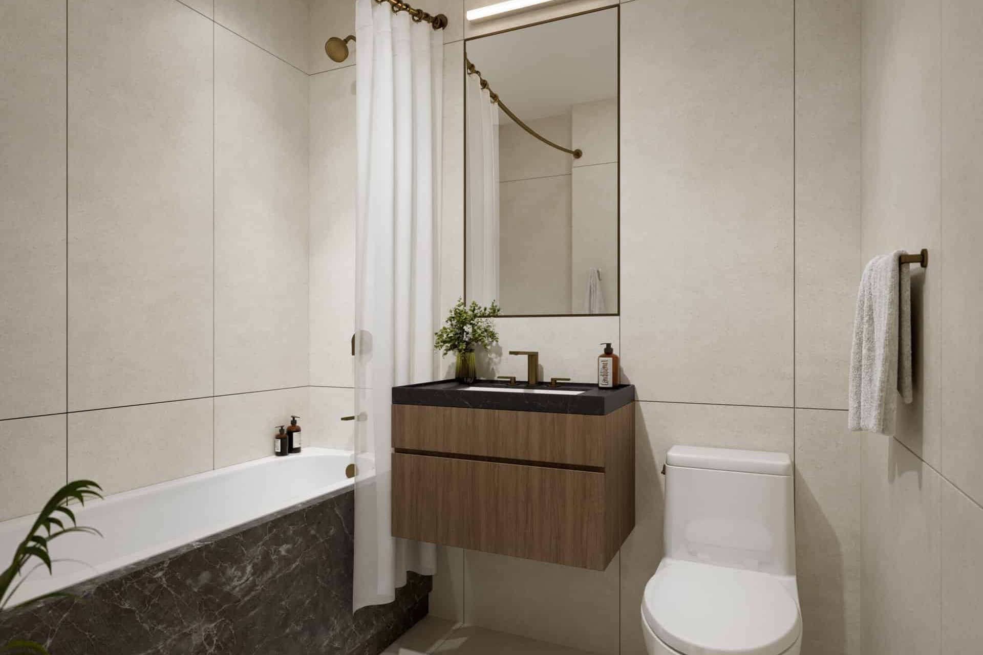 Bathroom at 231 East 76th Street apartment with tile walls, single vanity, a rectangle mirror and soaking tub with shower.