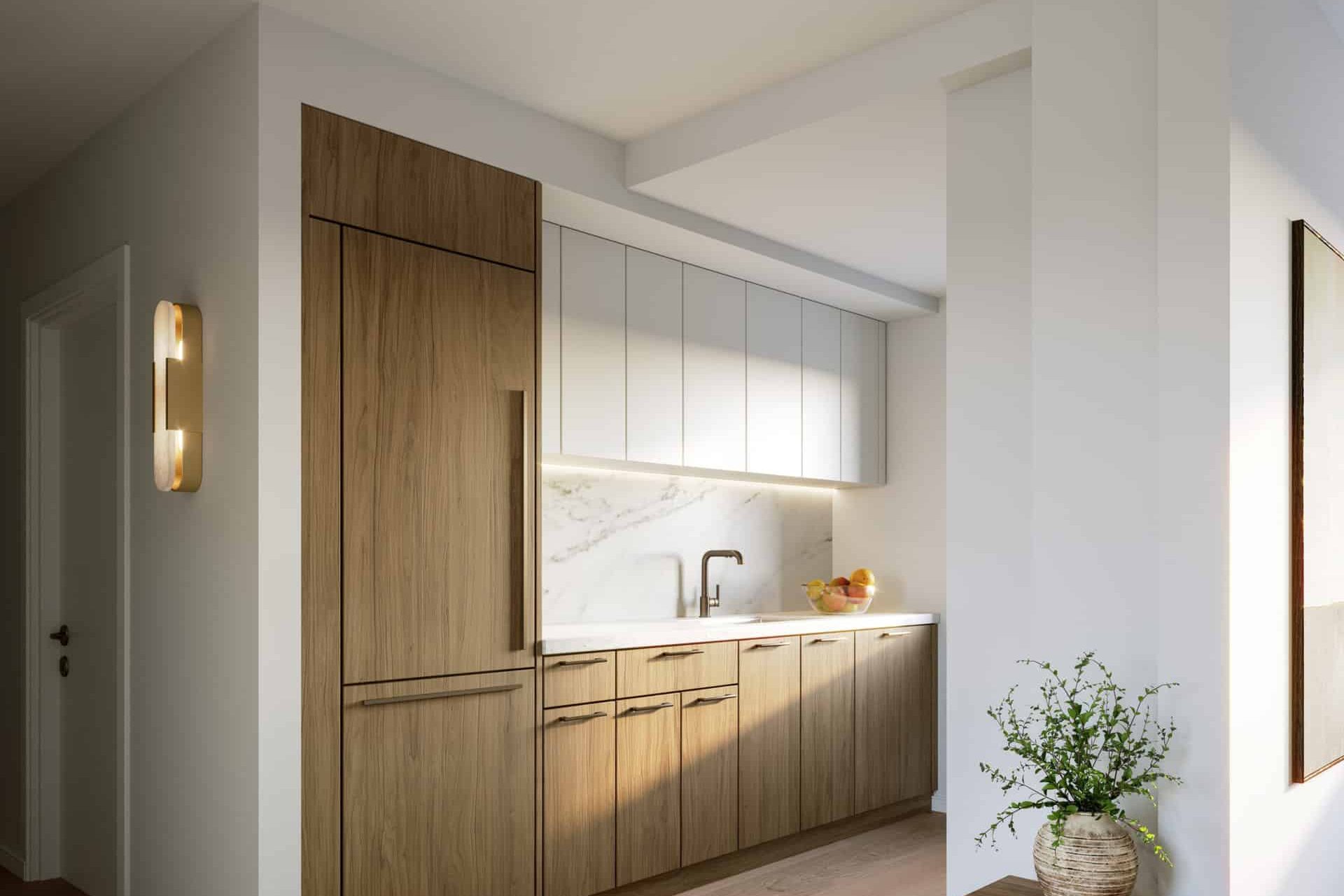 Galley kitchen at 231 East 76th Street apartments with white stone countertops, wood cabinets and hardwood floors.